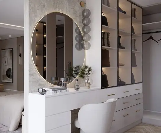 Vanity table with a circular illuminated mirror and glass-fronted shoe display, elegant home design West Midlands apartment interior design in West Midlands