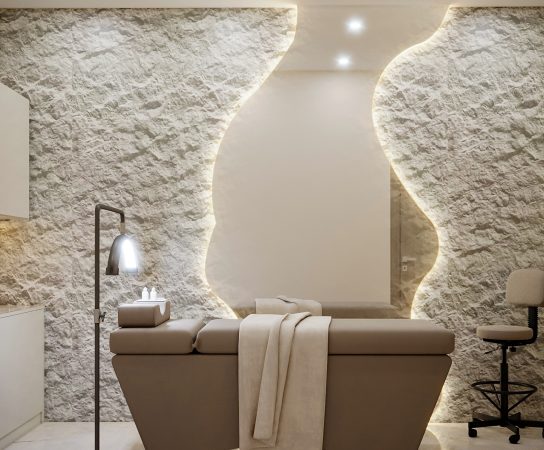 Calming Facial room with massage bed, stone feature wall and large irregular-shaped floor to ceiling mirror, luxury beauty salon interior design in Dubai