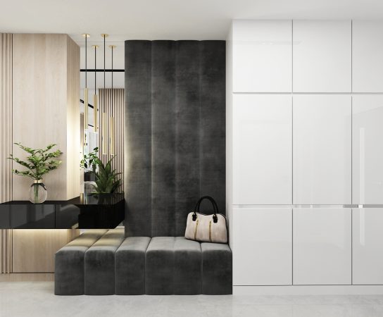 Close-up of a modern villa entry console featuring high-gloss white cabinets and a dark upholstered feature wall.