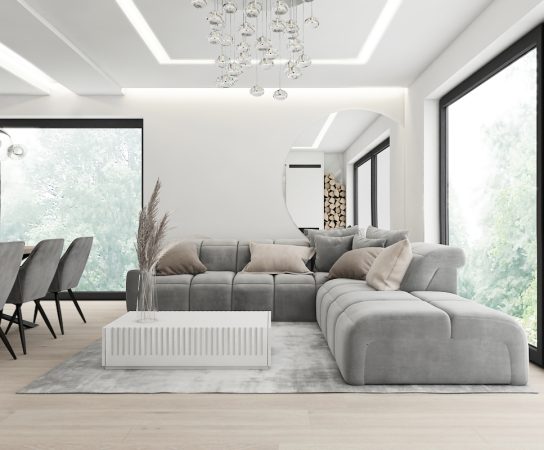 Open-plan minimalist living room in a luxury Dubai villa with a large grey sectional sofa and floor-to-ceiling windows.