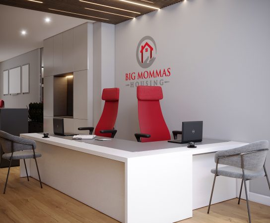 Minimalist office reception desk with two red high-back executive chairs and the Big Mommas Housing company logo on a light gray wall.